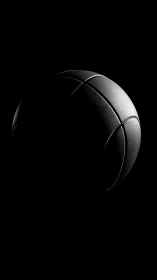 Basketball surface is partially illuminated against black ground