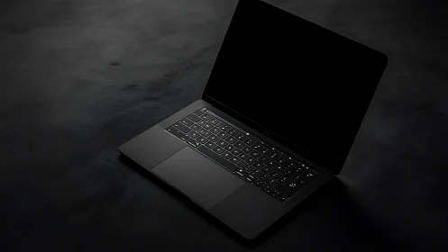 Sleek black laptop in moody low key studio lighting setup.