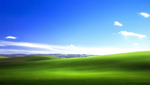 Grassy rolling hills under clear blue daytime sky panorama.