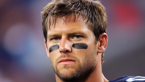 Focused football player stands ready under bright stadium lights