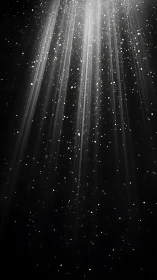 Radiant beams of white light descend through starry darkness.