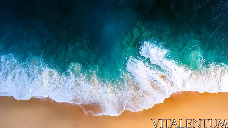 Overhead shoreline with teal waves meeting sand beach.