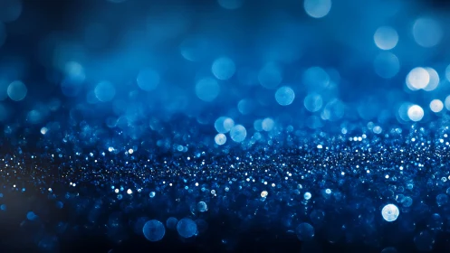 Blue glitter bokeh field under shallow macro focus glow.