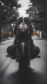 Front view of black motorcycle on wet urban roadway.