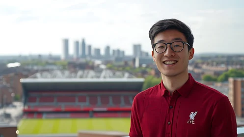 Smiling supporter in red shirt overlooking modern stadium.