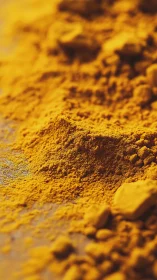 Fine yellow powdered spice forms a shallow uneven mound
