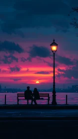 Chromatic waterfront sunset with silhouetted bench observers.