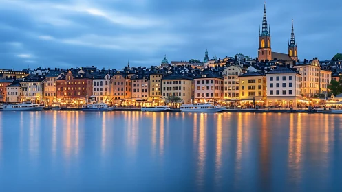Waterfront European city skyline with lit historic buildings.