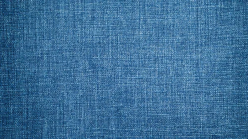 Textile macro of woven blue fabric with grid grain structure.