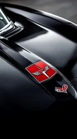 Close-up of classic Corvette hood emblem on gloss black body