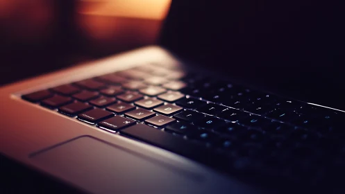 Laptop keyboard glows softly in warm evening light.