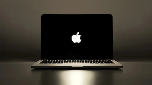 Illuminated laptop logo isolated against minimal dark backdrop