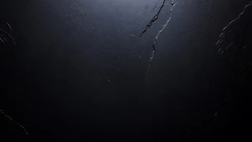 Dark slate surface shows subtle cracks under soft light