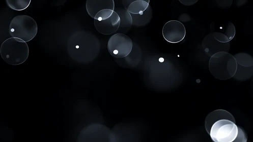 Defocused luminous bokeh spheres drift across a deep black field