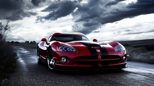 Red sports car on wet rural road under overcast sky.