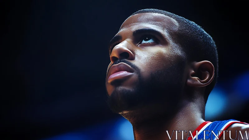 Focused basketball player under arena lights in profile.