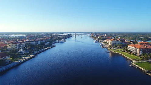 Riverside waterfront neighborhood with bridge and blue sky.
