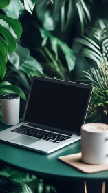 Laptop and coffee cups on green table in dense indoor plants