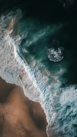 Aerial shoreline study with teal surf and warm sand.