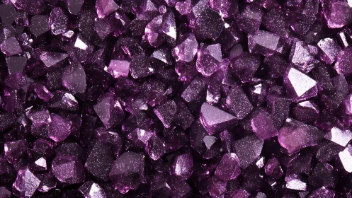 Macro field of faceted violet crystals under hard lighting.