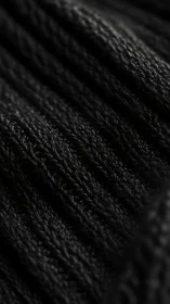 Black ribbed knit textile in close macro fabric view.