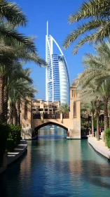 Sunlit waterfront canal frames a soaring modern Dubai landmark