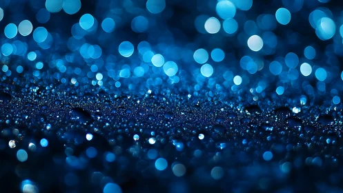 Blue macro bokeh with dewdrops over shimmering surface.