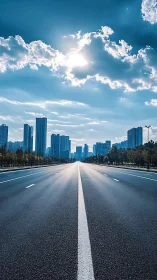 Empty city avenue stretches toward skyline under bright sun.