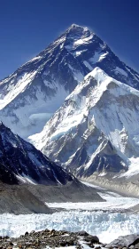 High altitude glaciated peak with stratified rock faces under clear sky