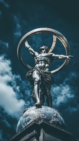 Heroic metal statue of muscular figure holding rings aloft.