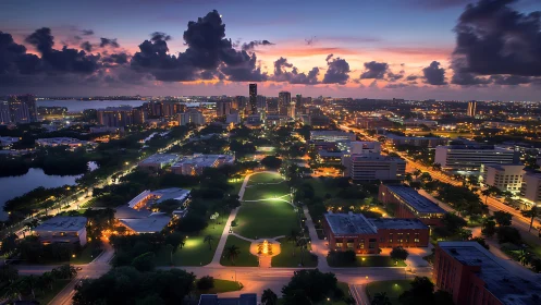 Urban skyline overlooks illuminated city park at dusk