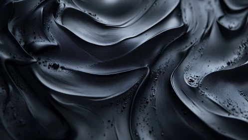 Metallic black fluid waves form sculpted abstract surface