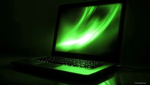 Luminous green laptop screen glows in a darkened workspace.