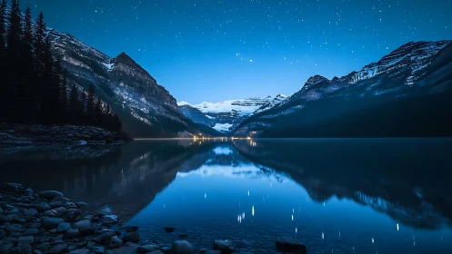 Nighttime alpine lake with starry sky and mountain reflections.