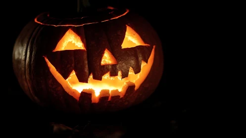 Grinning jack o’ lantern blazing mischief in velvet dark.