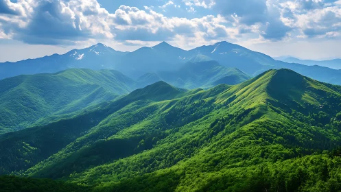Sunlit green mountain ridges under distant blue peaks.