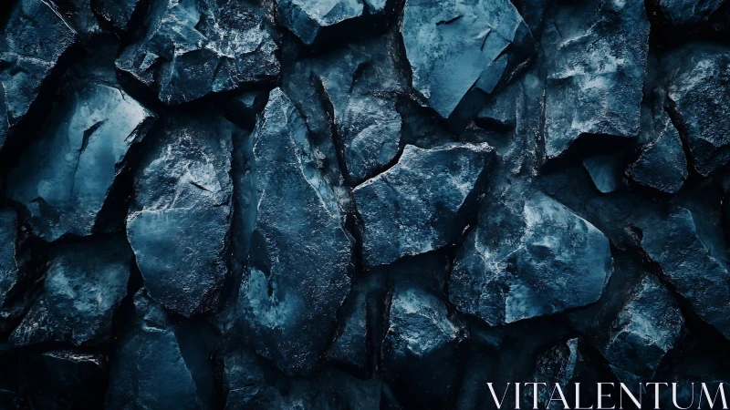 Dark fractured rock surface shows irregular angular structure