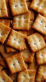 Stacked square crackers with perforations and salt granules visible.