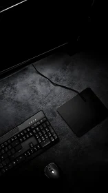 Computer keyboard, mouse and pad on dark textured desk