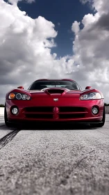 Low-angle frontal study of red sports coupe under dramatic cumulus sky