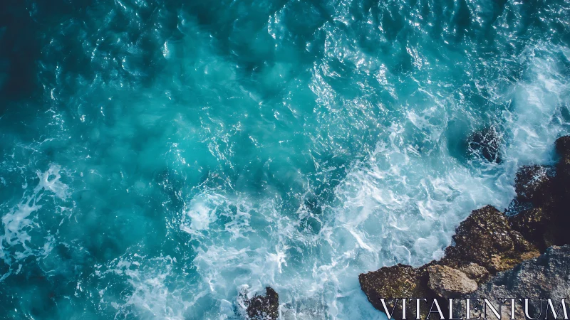 Turquoise ocean waves break against rugged coastal rocks.