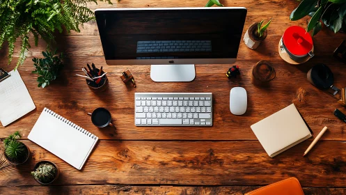 Organized wooden desk with desktop computer and plants.