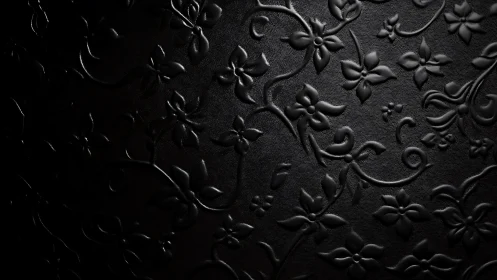 Embossed black leather floral wallpaper under side light.