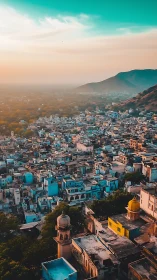 Sunlit hill city skyline under teal sky at golden hour.