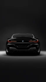 Rear view of black BMW sports coupe on dark background.