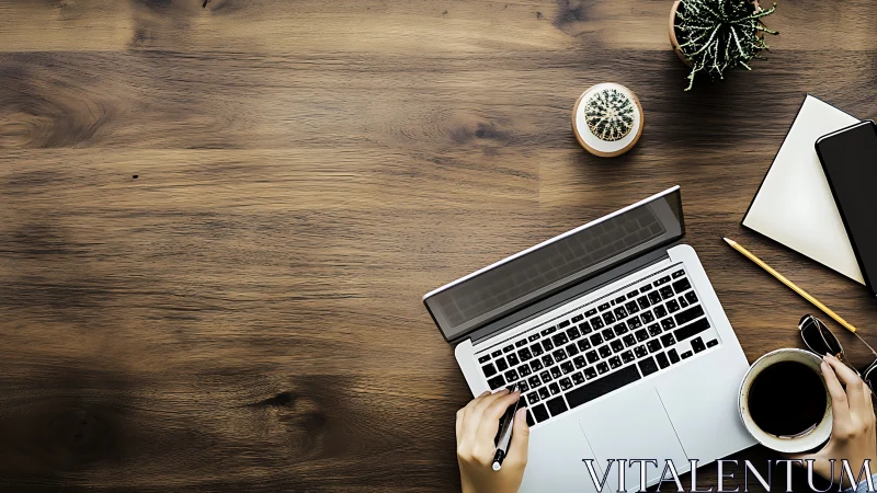 Overhead workspace with laptop, coffee mug, notebook, succulents