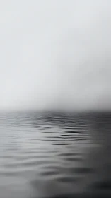 Monochrome rippled water plane dissolves into atmospheric fog