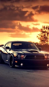 Black muscle car sits on open road under vibrant sunset sky