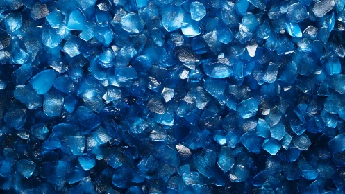 Close view of scattered glossy blue glass crystal chips.