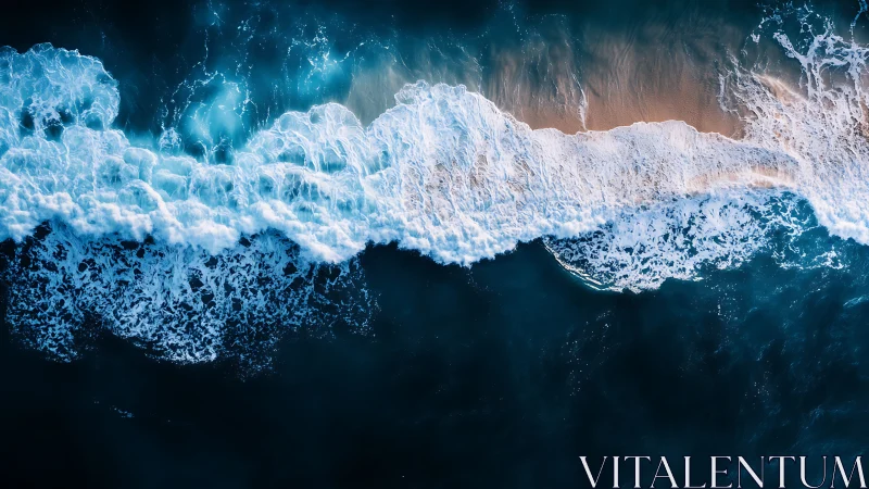 Vertical aerial view of shoreline waves meeting sand.
